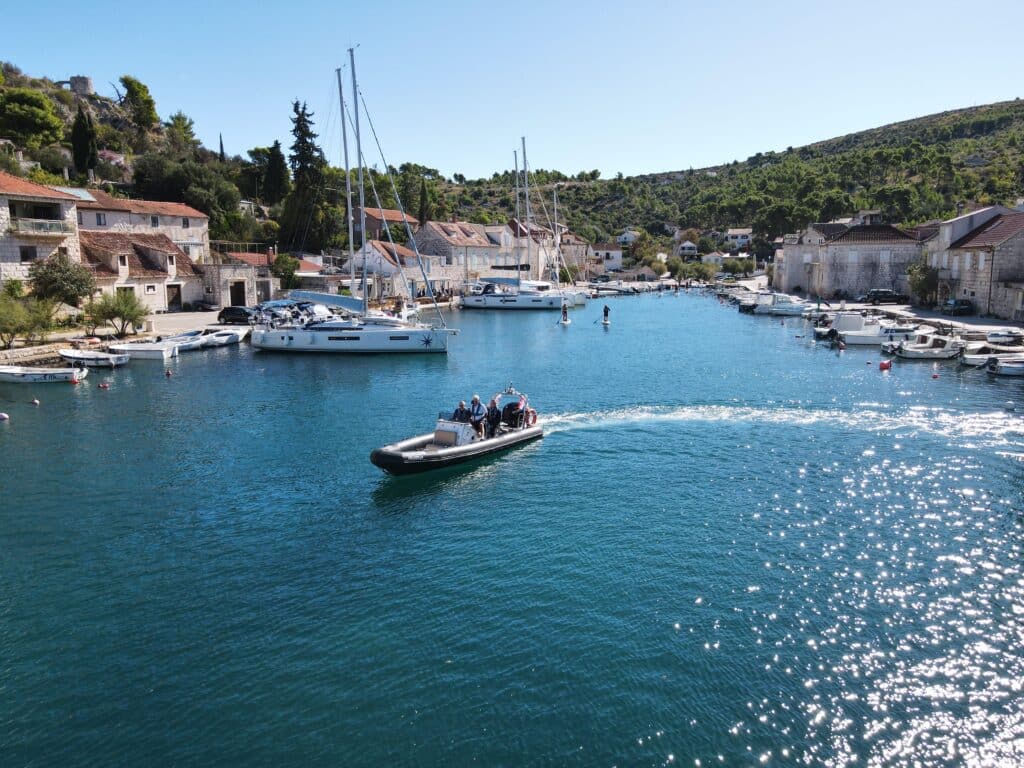 A modern powerboat navigating through a busy marina in Milna during an RYA Powerboat Level 2 training course.