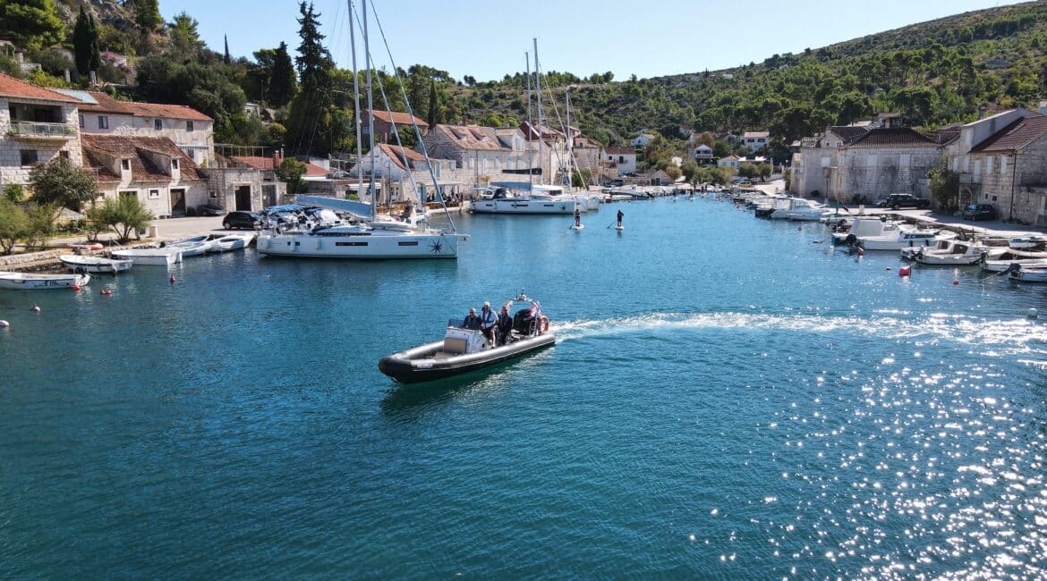 A modern powerboat navigating through a busy marina in Milna during an RYA Powerboat Level 2 training course.